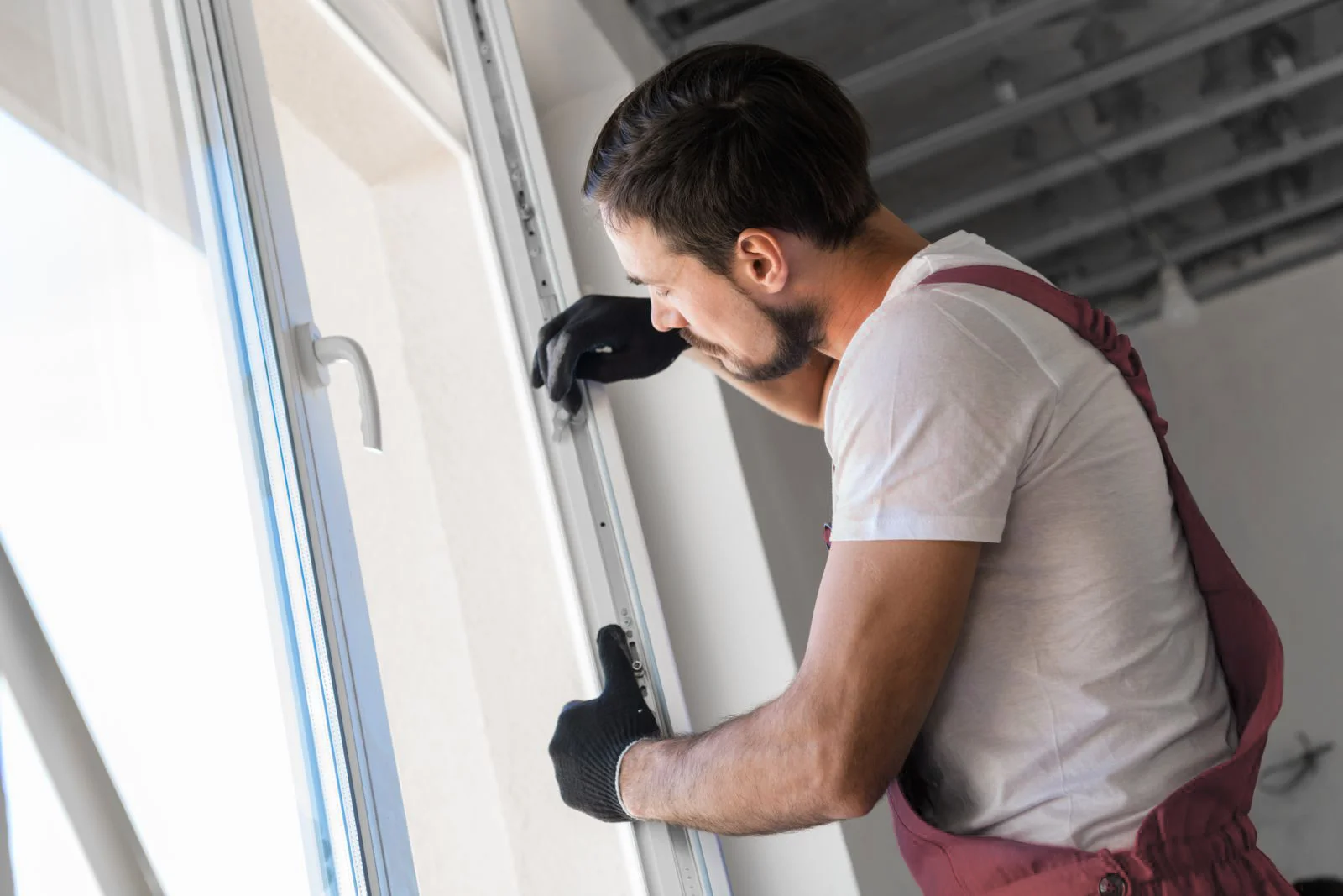 Technician cleaning and lubricating window track mechanism, maintenance service work